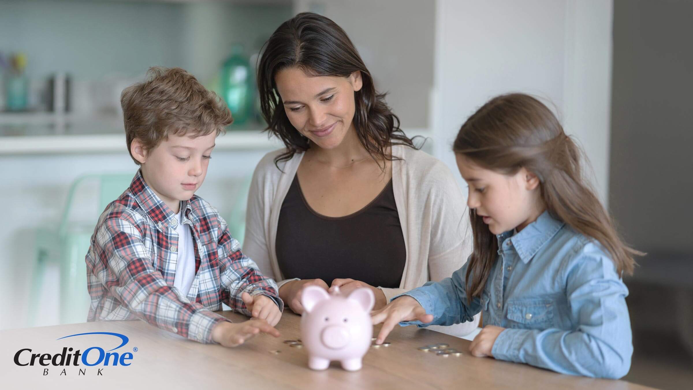 A young mom and her two children sit at the kitchen table counting money from their piggy bank, which is an early step to teaching kids about building credit.