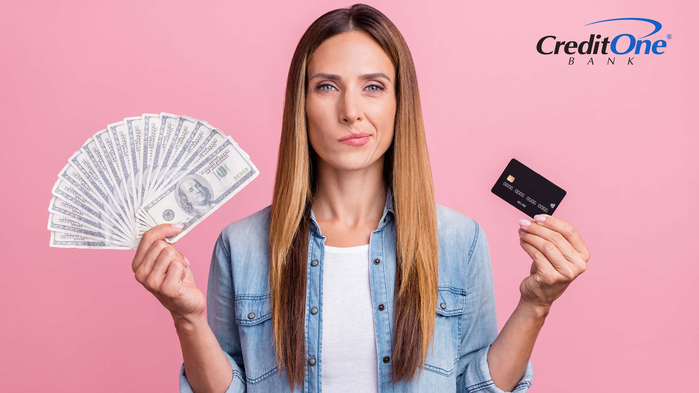 A woman holds up several $100 bills in her right hand and a credit card in her left, with a indecisive expression. Perhaps she is currently deciding whether cash or card is better.